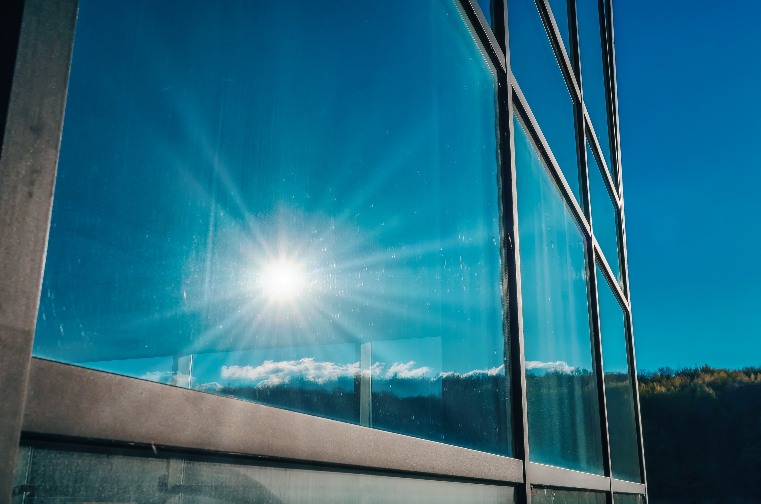 Glass windows of a modern building. Sunlight is reflected in the glass
